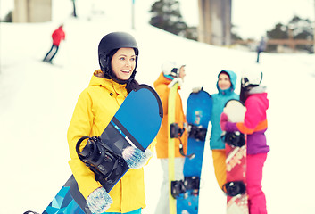 Image showing happy friends in helmets with snowboards