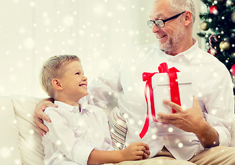 Image showing smiling grandfather and grandson with gift box