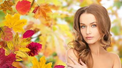 Image showing beautiful young woman face over autumn leaves