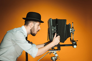 Image showing young man with retro camera 