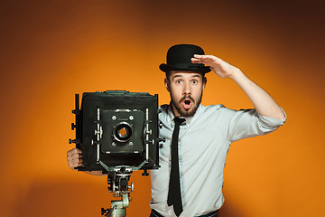 Image showing young man with retro camera 