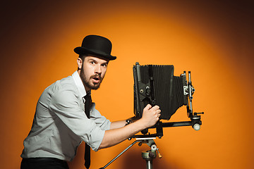 Image showing young man with retro camera 