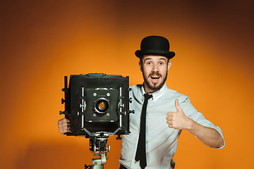 Image showing young man with retro camera 