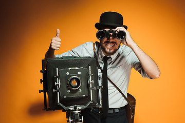 Image showing young man with retro camera 