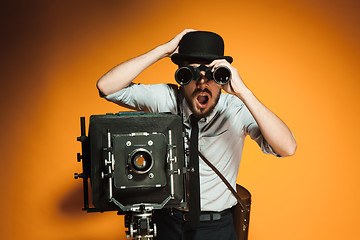 Image showing young man with retro camera 