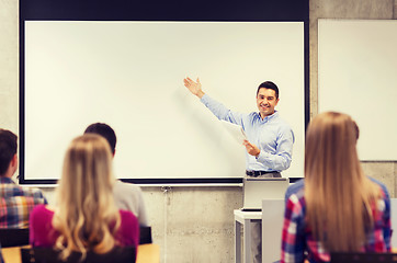 Image showing group of students and smiling teacher with notepad