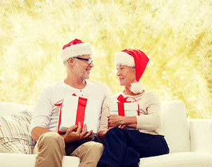 Image showing happy senior couple in santa hats with gift boxes