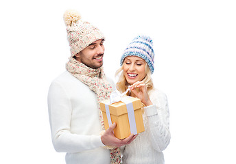 Image showing smiling couple in winter clothes with gift box