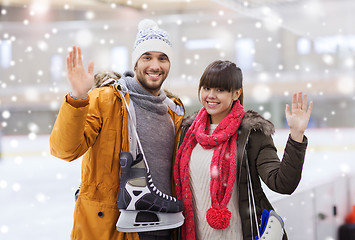 Image showing happy couple with ice-skates on skating rink