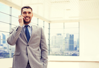 Image showing happy young businessman calling on smartphone