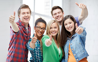 Image showing group of happy students showing thumbs up
