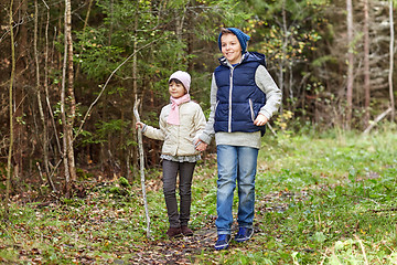 Image showing two happy kids walking along forest path