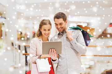 Image showing couple with tablet pc and shopping bags in mall