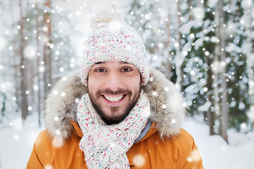 Image showing smiling young man in snowy winter forest
