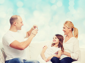 Image showing happy family with camera at home