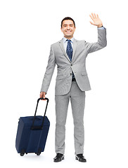 Image showing happy businessman in suit with travel bag