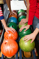 Image showing players hands and ball return system in bowling