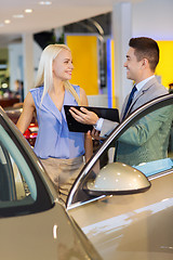 Image showing happy woman with car dealer in auto show or salon