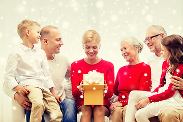 Image showing smiling family with gift at home