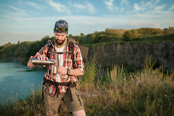 Image showing Young caucasian man with backpack resting and drinking water