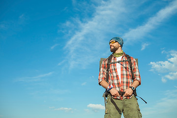 Image showing Young caucasian man with backpack standing on the top of hill