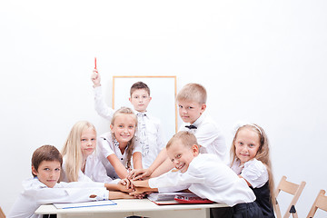 Image showing group of teen pupils. They holding their hands together