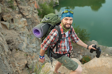 Image showing Young caucasian man with backpack climbing the rock