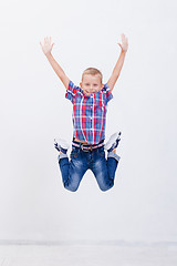 Image showing happy young boy jumping  on white background