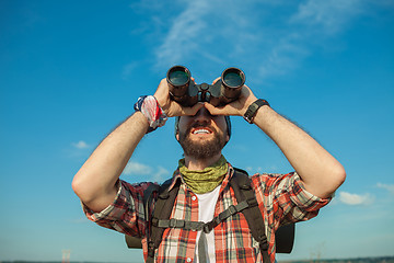 Image showing Young caucasian man with backpack standing on the top of hill