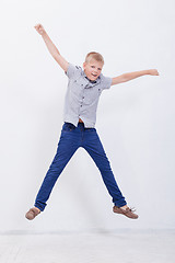 Image showing happy young boy jumping  on white background