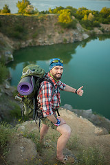 Image showing Young caucasian man with backpack standing on the top of hill