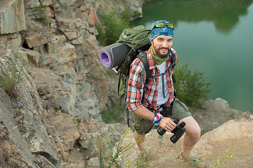 Image showing Young caucasian man with backpack climbing the rock