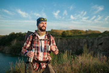 Image showing Young caucasian man with backpack resting and drinking water