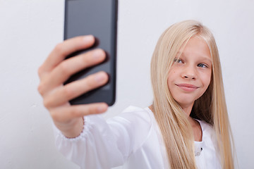 Image showing pretty teen girl taking selfies with her smart phone