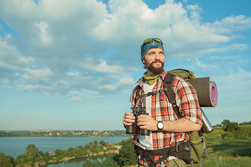 Image showing Young caucasian man with backpack standing on the top of hill