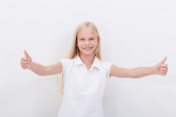 Image showing Portrait of a beautiful girl showing thumbs up on white