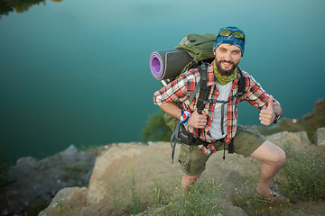 Image showing Young caucasian man with backpack climbing the rock