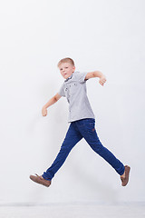 Image showing happy young boy jumping  on white background