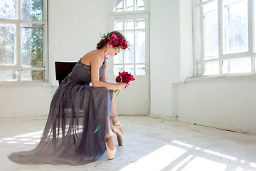 Image showing The beautiful ballerina sirtting in long gray dress 