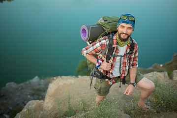 Image showing Young caucasian man with backpack climbing the rock