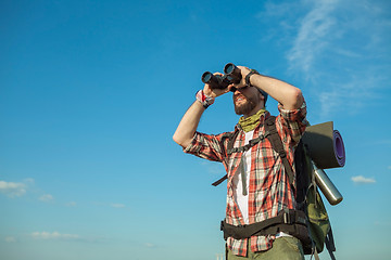 Image showing Young caucasian man with backpack standing on the top of hill