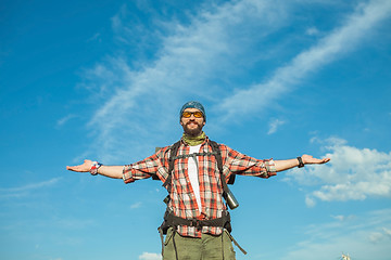 Image showing Young caucasian man with backpack standing on the top of hill