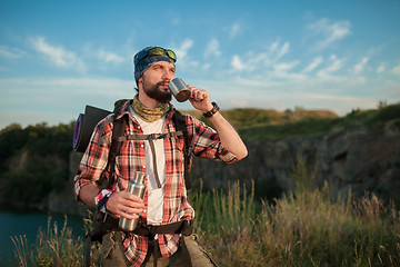 Image showing Young caucasian man with backpack resting and drinking water