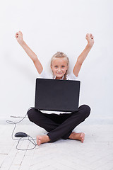 Image showing young teen girl with arms raised using laptop