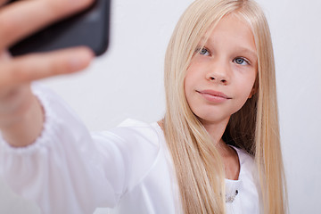 Image showing pretty teen girl taking selfies with her smart phone