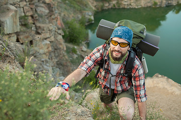 Image showing Young caucasian man with backpack climbing the rock