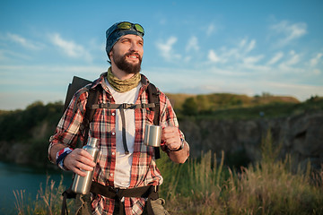 Image showing Young caucasian man with backpack resting and drinking water