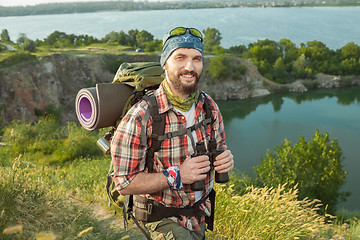 Image showing fully equipped tourist smiling on the background of lake