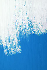 Image showing Blue board being roughly painted with white paint