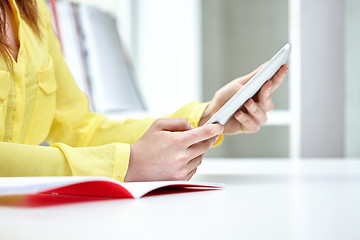 Image showing close up of female hands with tablet pc at table